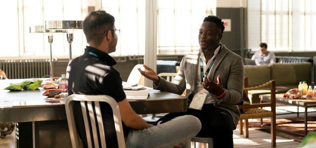 Two men sitting at a table and having a conversation